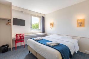 a hotel room with two beds and a red chair at Hôtel La Petite Auberge in Chambretaud