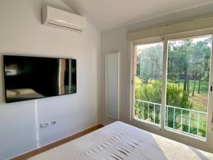 a bedroom with a bed and a large window at APARTAMENTO NUEVO URB ALTAVISTA VISTA CAMPO GOLF Aire Acondicionado y Wifi in Islantilla