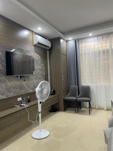 a living room with a fan and a tv at Ruby 3 Hotel in Hanoi