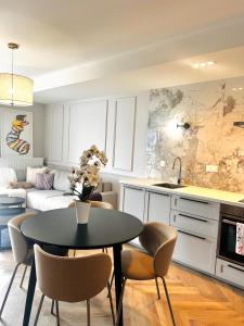 a kitchen and living room with a table and chairs at Downtown Apartments Podpromie Monica with UNDERGROUND PARKING in Rzeszów