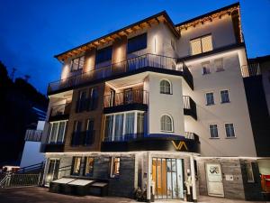 a tall white building with a balcony at Hotel Vista Allegra in Ischgl
