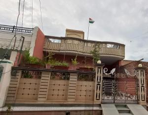 a building with a balcony with potted plants on it at Vashu's Sweet Home in Bikaner