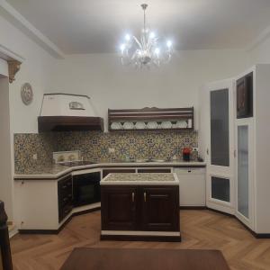 a kitchen with a chandelier in the middle of it at Casa Di Bella Taormina in Roccalumera