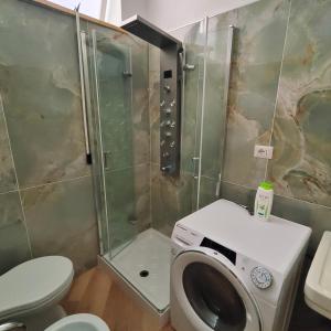 a bathroom with a shower and a toilet and a washing machine at Casa Di Bella Taormina in Roccalumera +11 photos