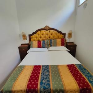 a bedroom with a large bed with a colorful blanket at Casa Di Bella Taormina in Roccalumera