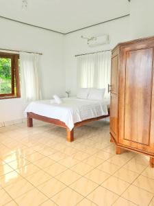 a bedroom with a bed and a wooden cabinet at Batu Belah Bungalows and Restaurant in Data +25 photos