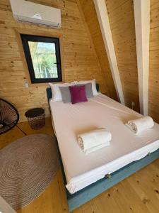 uma cama num chalé de madeira com uma janela em Panorama Pool Hills em Ledinci
