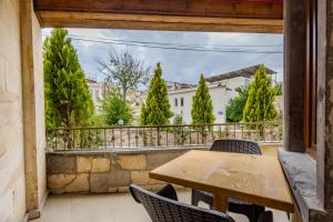 a wooden table and chairs on a balcony with trees at Leo's Cappadocia in Goreme