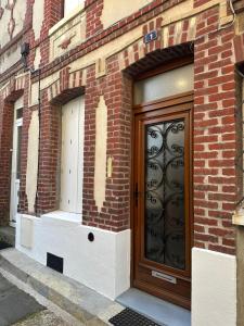 a door on the side of a brick building at maison de pêcheur in Fécamp