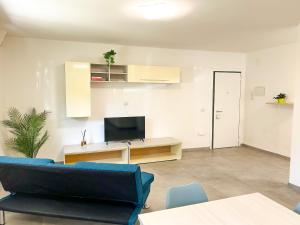 a living room with a blue couch and a tv at La Casetta di Lusì in Rimini