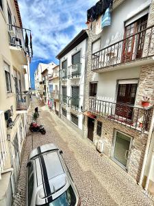 un'auto parcheggiata in una strada accanto agli edifici di Casinha do Carapau - Nazaré a Nazaré