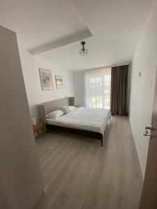 a bedroom with a bed and a large window at Home Away Bistrița in Bistriţa