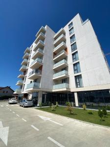 a large white apartment building with a parking lot at Home Away Bistrița in Bistriţa +36 photos