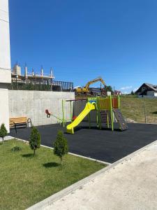 a playground with a slide in a park at Home Away Bistrița in Bistriţa