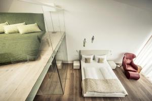 a bedroom with a bed and a mirror and a chair at MALAT Weingut und Hotel in Furth