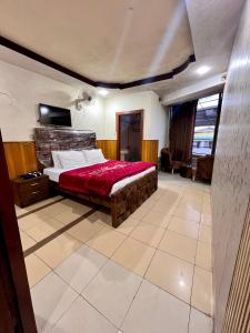 a bedroom with a bed with a red blanket at Islamabad premier inn hotel murree in Murree