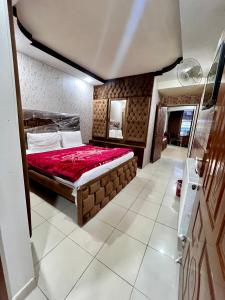 a bedroom with a large bed with a red blanket at Islamabad premier inn hotel murree in Murree