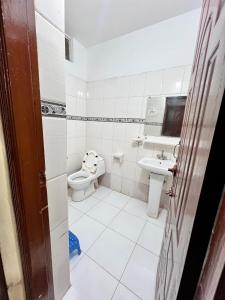 a white bathroom with a toilet and a sink at Islamabad premier inn hotel murree in Murree