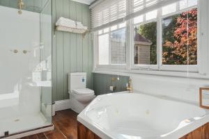 a bathroom with a tub and a toilet and a window at Franklin Lodge, Huon Valley, Tasmania, Lavender Room in Franklin