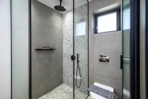 a shower with a glass door in a bathroom at Theros Hani Sea in Kokkíni Khánion +31 photos