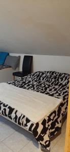 a bed with a black and white blanket on it at Studio Vissoie in Vissoie