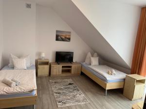 a attic room with two beds and a tv at Asteria Odargowo in Krokowa