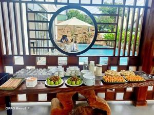 une table avec des assiettes de nourriture et un miroir dans l'établissement Vooc Signature Hotel Hoi An, à Hội An