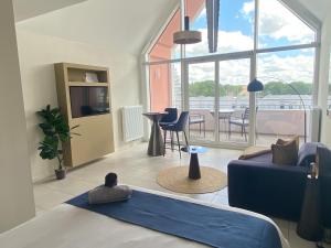 a living room with a blue couch and a view of a balcony at La Suite Design Dunkerque Plage à 50 mTerrasse Sud in Dunkerque