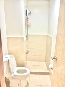 a small bathroom with a toilet and a shower at 40sqm Minimalist Condo w Balcony SM Marilao in Marilao