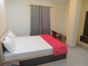 a bedroom with a bed with a red blanket on it at HOTEL DEV INN, Begusarai in Jāmb