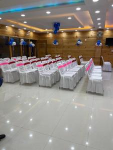 a room with white and pink tables and chairs at HOTEL DEV INN, Begusarai in Jāmb