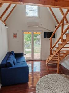 a living room with a blue couch and a staircase at Vila Dobrila, Tenis kućica in Avala