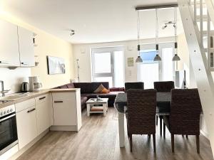 a kitchen and living room with a table and chairs at Ferienwohnung De Eller in Dorum