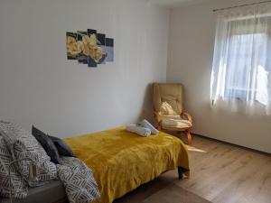a bedroom with a bed and a chair next to a window at kuća za odmor Dolno in Sisak