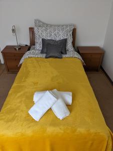 a yellow bed with two towels on top of it at kuća za odmor Dolno in Sisak