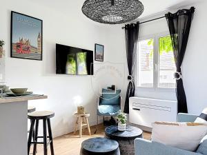 a living room with a blue couch and chairs at La Tourelle des Rois in Dourdan