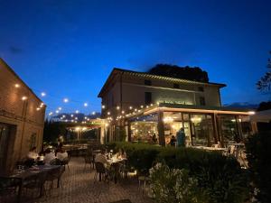 people sitting at tables outside of a restaurant at night at La Locanda Paradiso in SantʼEgidio