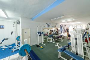 a gym with treadmills and machines in a room at Holiday Home & Apartments Primavera in Pula