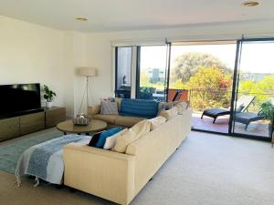 a living room with a couch and a television at Coastal Comfort Pool, Golf, Beach, Room for 8 in Torquay