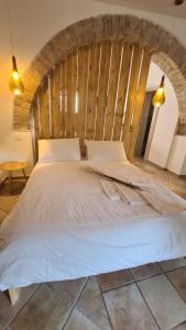 a bedroom with a white bed with a wooden wall at Molise Garden Apartments Renato in Boiano