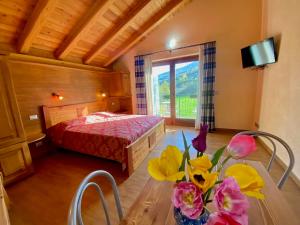 a bedroom with a bed and a table with flowers on it at Village Paradis in Roisan
