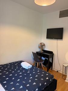 a bedroom with a bed and a desk with a television at Cozy Double bed room in London