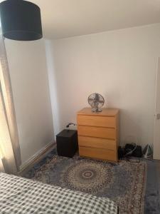 a bedroom with a bed and a dresser with a lamp at Cozy Double bed room in London