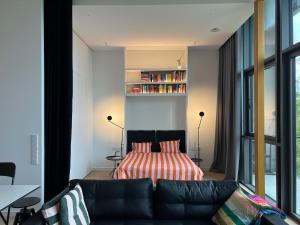 un soggiorno con divano e letto di Design apartment with view to Nemunas, Prienai a Pakopi