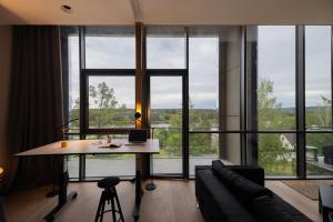 un soggiorno con un tavolo e una grande finestra di Design apartment with view to Nemunas, Prienai a Pakopi