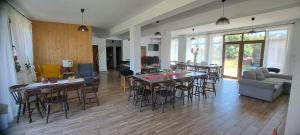 a living room with tables and chairs and a couch at Porumbacu381 - Casa de Oaspeti Faini in Porumbacu de Sus