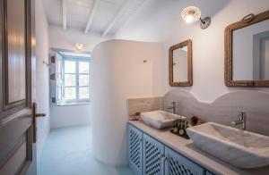 a bathroom with two sinks and a mirror at Theologos Houses in Grikos +93 photos