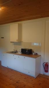 a kitchen with white cabinets and a counter top at Studio apartment 48m2 in Hølera