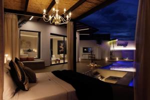 a bedroom with a bed and a living room at Emerald Villas & Suites - The Finest Hotels Of The World in Agios Nikolaos