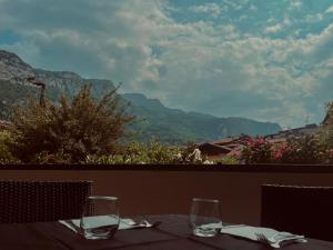 a table with two wine glasses sitting on a balcony at Hotel De Nac in Nago-Torbole